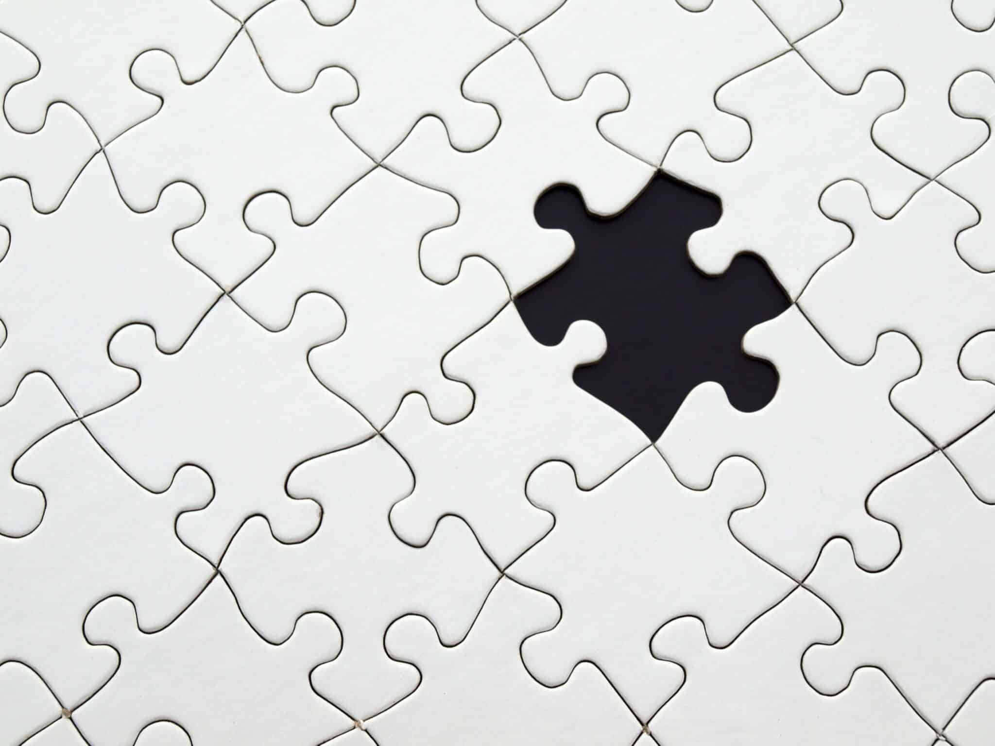 White puzzle black background with a missing piece