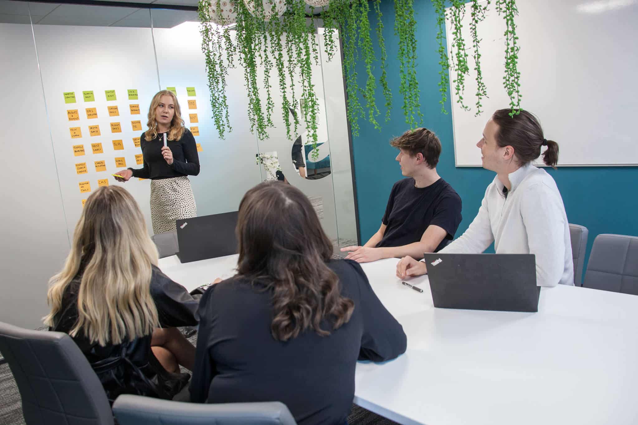 team gathered in a meeting room discussing marketing strategy