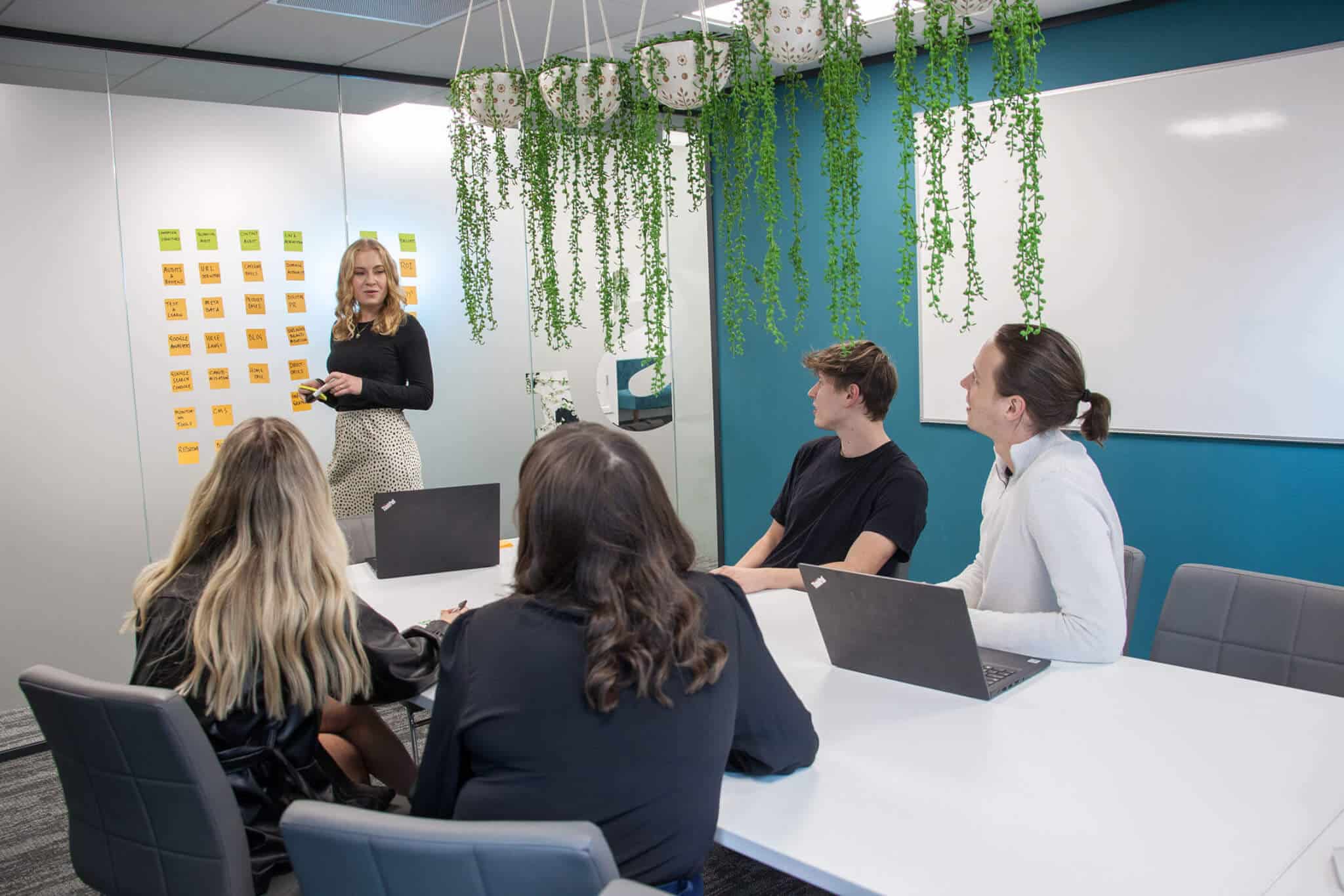team in an office having a meeting with laptops