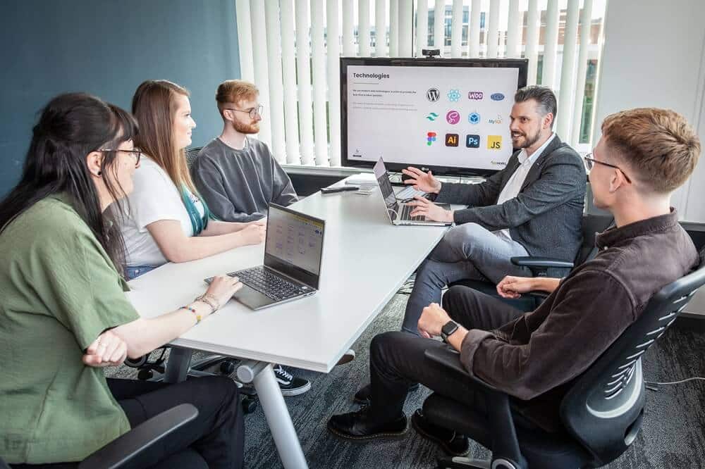 medical website design team having a team meeting in an office around a desk